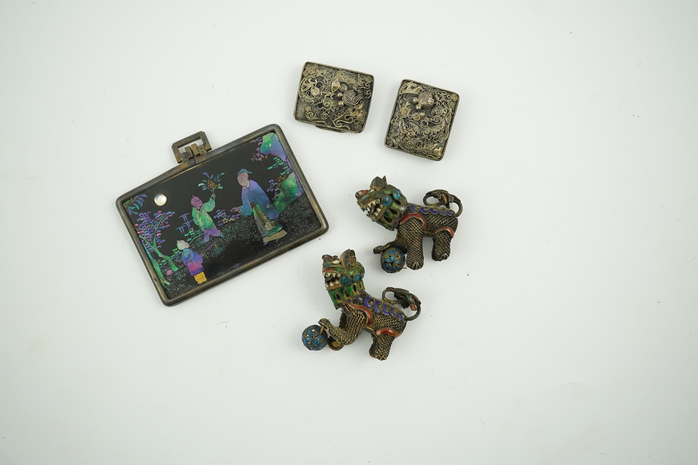 A Chinese silver buckle with filligree butterfly decoration, a pair of enamelled miniature lion dogs with balls and a small lac burgaute panel. Lion dogs 4.5cm long. Condition - good